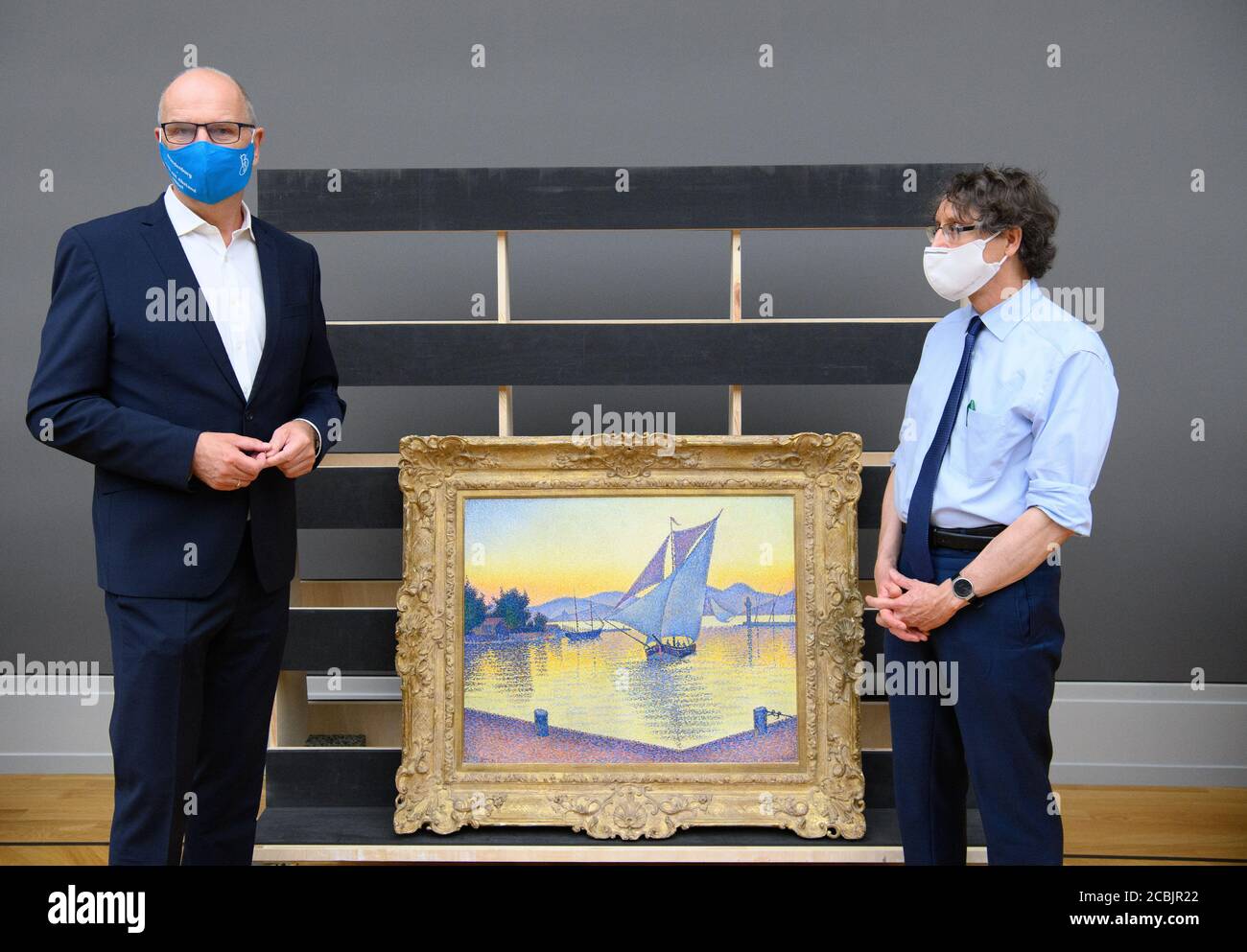 14 August 2020, Brandenburg, Potsdam: Dietmar Woidke (l, SPD), Minister President of Brandenburg, stands next to Chief Curator Michael Philipp during his press tour at the Barberini Museum. Between them stands the painting "The Harbor at Sunset, Opus 236 (Saint-Tropez 1892)" by Paul Signac. During the closing phase of the museum, there was a view of the new exhibition "Impressionism. The Hasso Plattner Collection", which will open on 07.09.2020. Potsdam is thus to become one of the most important centres of collections of Impressionist landscape painting worldwide outside of Paris. Photo: Soer Stock Photo