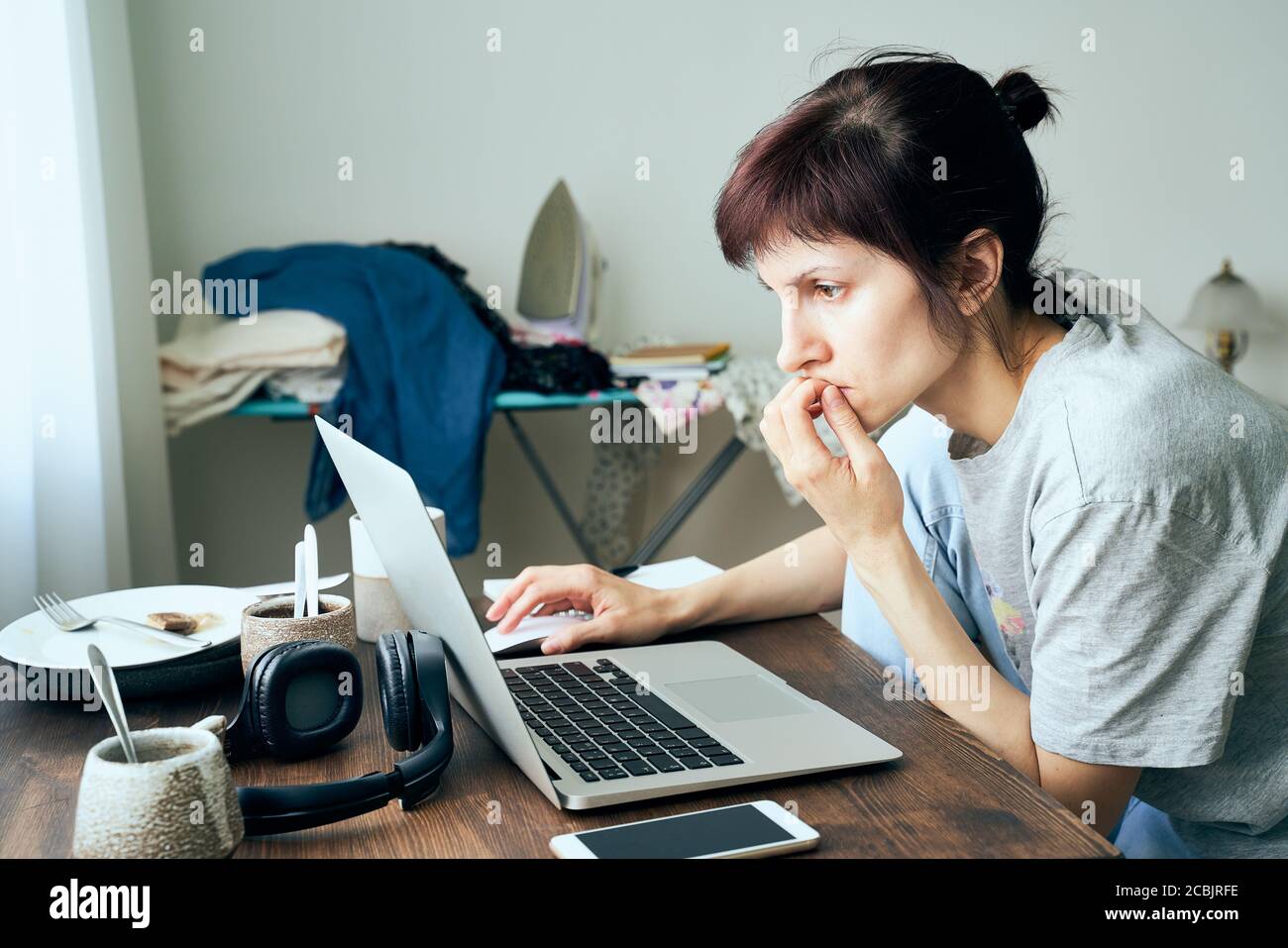 Digital addiction, woman in panic reads articles about coronavirus on Internet, Stock Photo