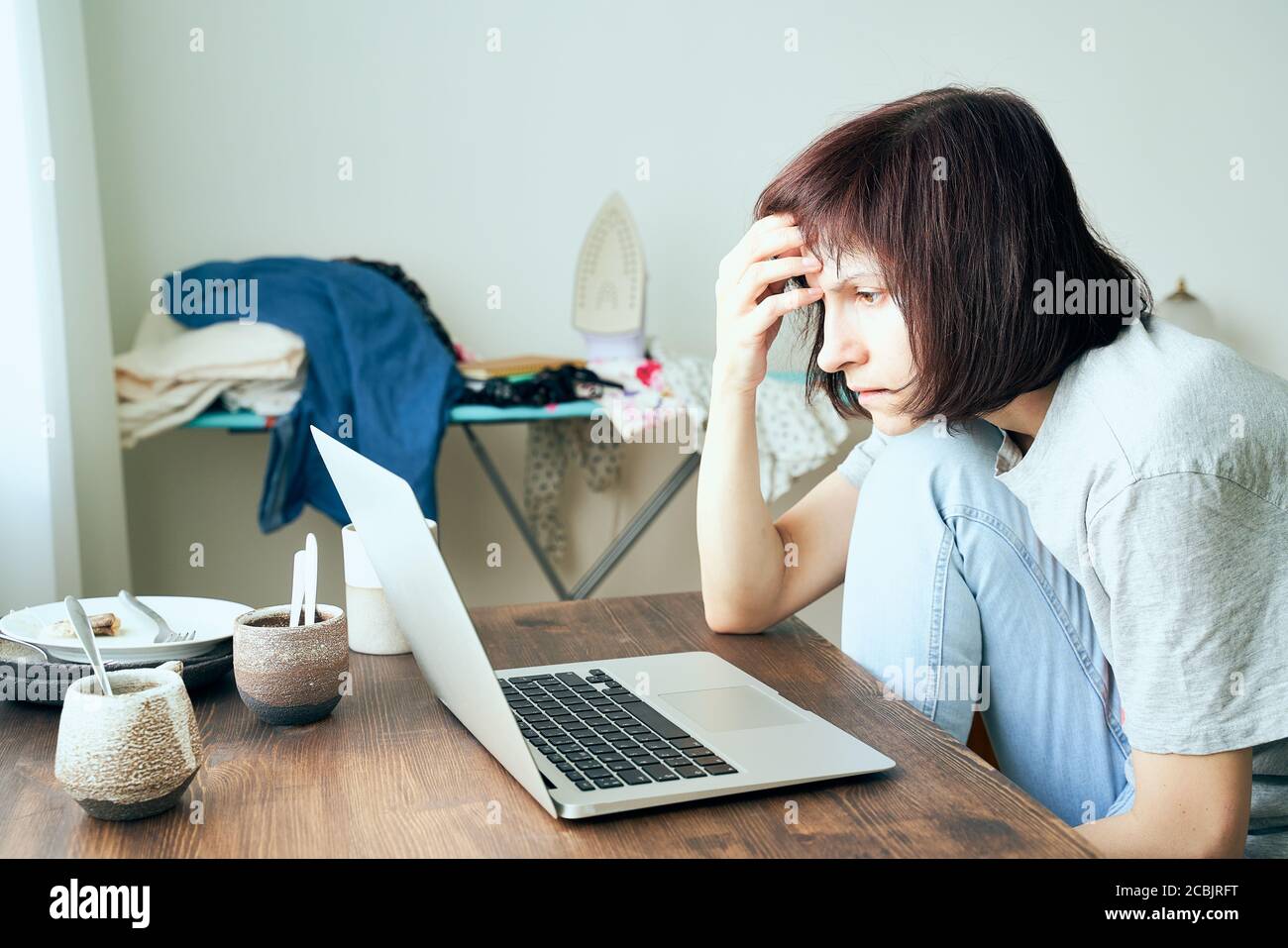 Digital addiction, woman in panic reads articles about coronavirus on Internet Stock Photo