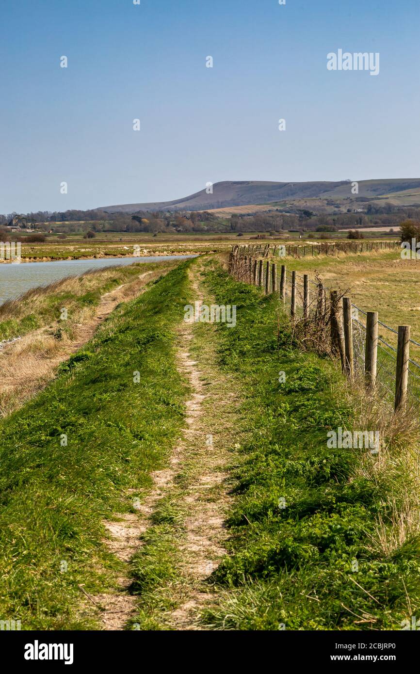 A pathway running alongside the River Ouse in Sussex, with a blue sky overhead Stock Photo