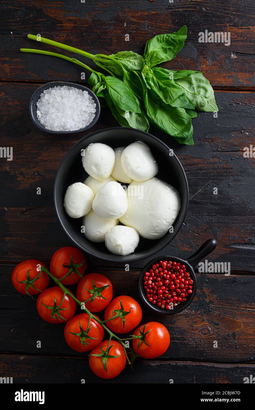 Raw ripe Mozzarella cheese balls with fresh basil leaves and cherry tomatoes, the ingredients