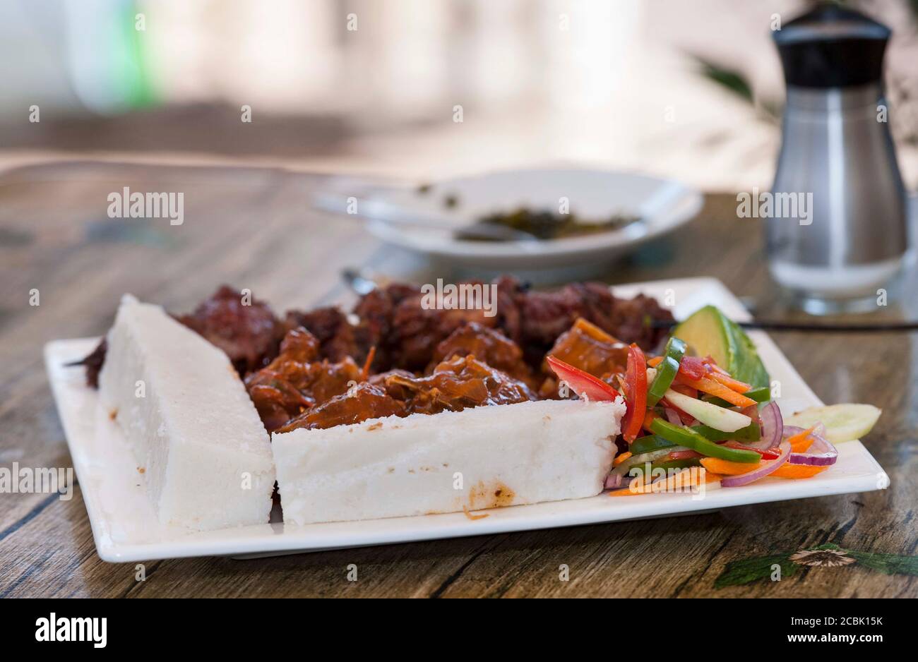 Nsima, or ugali or posho, is a main meal for millions of people in sub-Saharan Africa. Popularly eaten with nyama choma, goat meat or just greens Stock Photo