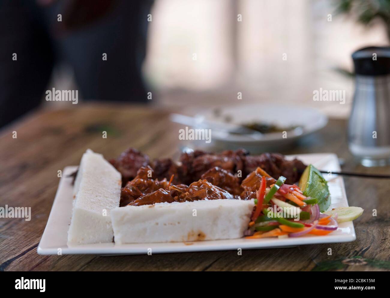 Nsima, or ugali or posho, is a main meal for millions of people in sub-Saharan Africa. Popularly eaten with nyama choma, goat meat or just greens Stock Photo