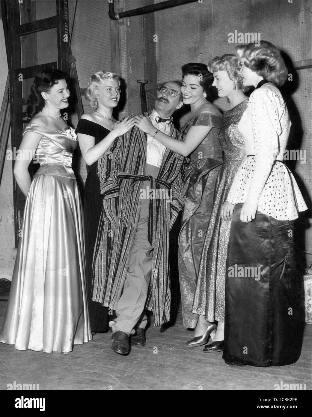 GROUCHO MARX on set candid with pretty actresses during the filming of his cameo appearance in MR. MUSIC 1950 director RICHARD HAYDN Paramount Pictures Stock Photo
