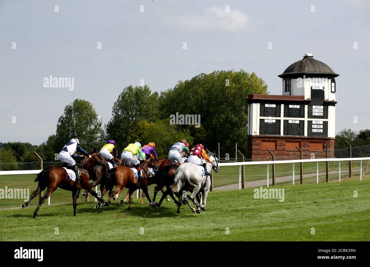 Runners and riders pass the fixtures board as they compete in the Mary Clark 'Favourite Day Of The Year' Handicap (Division 2) at Pontefract Racecourse. Stock Photo