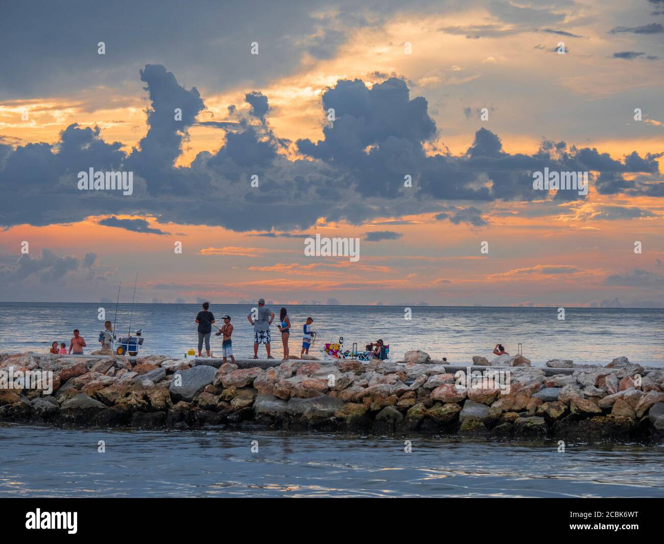 Colorful orange sky at dusk over the Gulf of Mexico at the North Jetty in Nokomis Florida taken from the south Jetty in Venice Florida in the United S Stock Photo