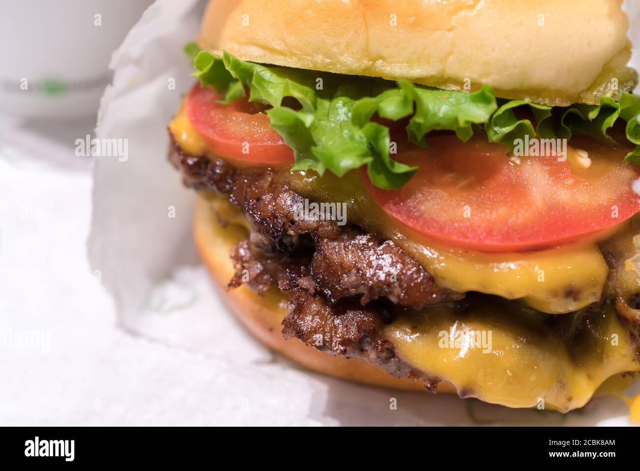 Double cheeseburger with tomato lettuce and onion, Cheese Fries and Milkshake. Stock Photo