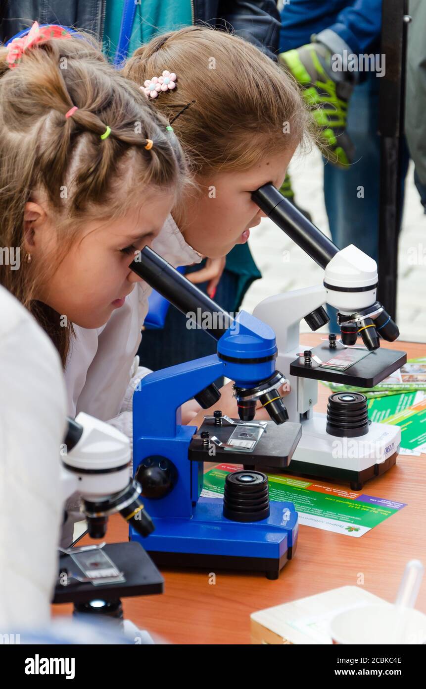 Kyiv, Ukraine - September 28, 2019. Shevchenko park. Two curious little girls looking through microscopes. Concept of popularization of science Stock Photo