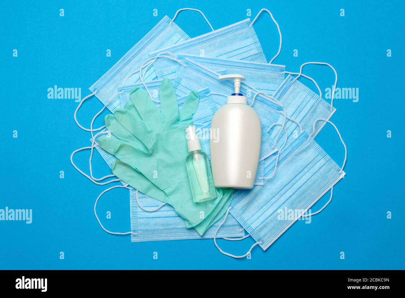 Stack of Disposable blue medical face masks, rubber latex gloves and