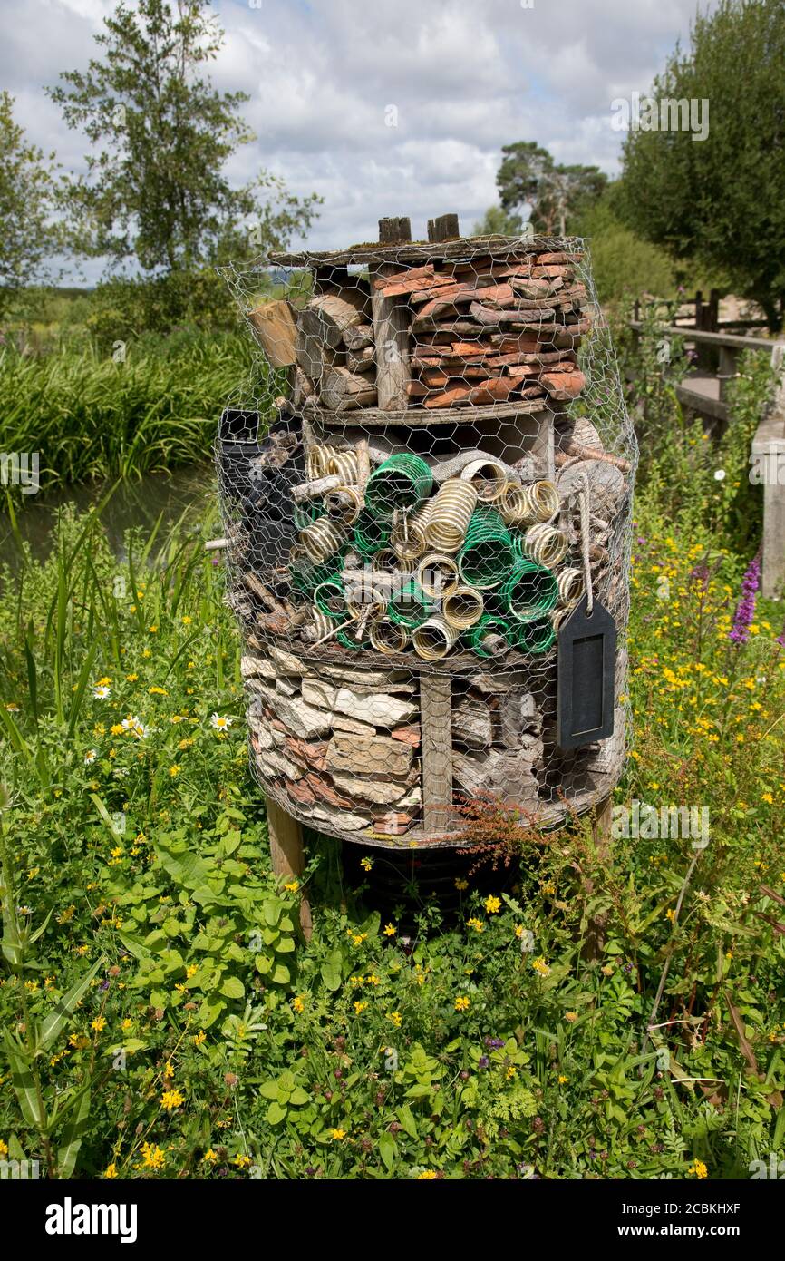 Large insect hotel built from old clay pipes, pastic corrugate tube ...