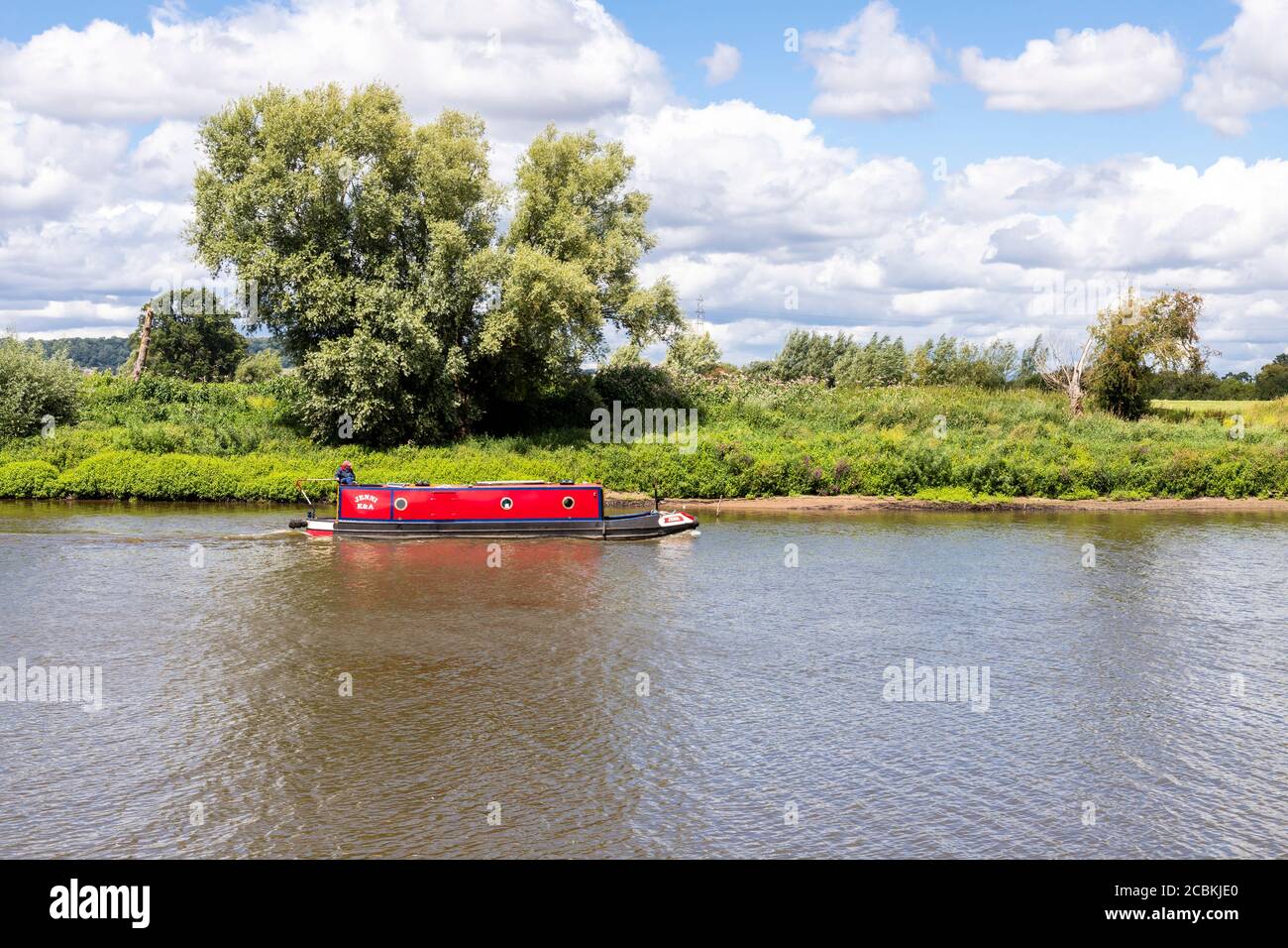 A barge or longboat cruising on the River Severn at Wainlode, Gloucestershire UK Stock Photo
