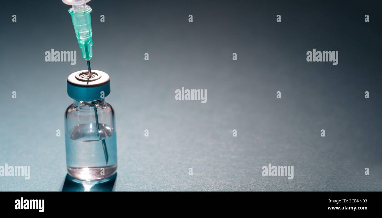 Vaccine, coronavirus vaccination, covid-19 flu prevention, immunization concept. Vial dose and medical syringe, drug medicine shot injection, gray blu Stock Photo