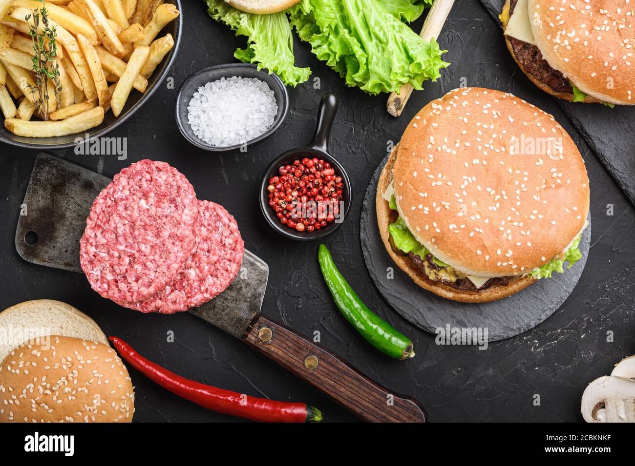 Homemade beef burgers with ground beef cutlets on black textured background Stock Photo