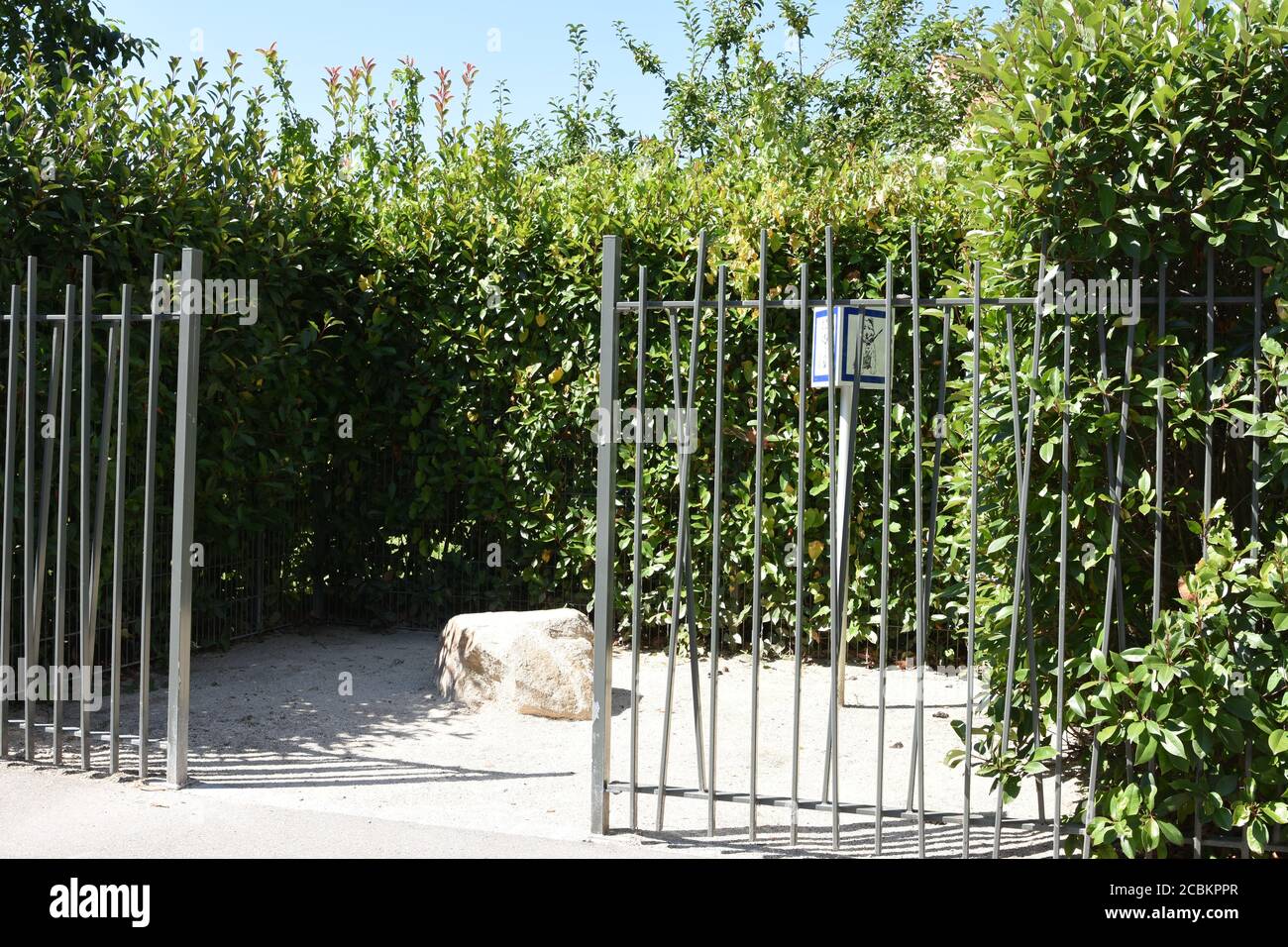 Fenced outdoor dog potty area and potty station with pea gravel and