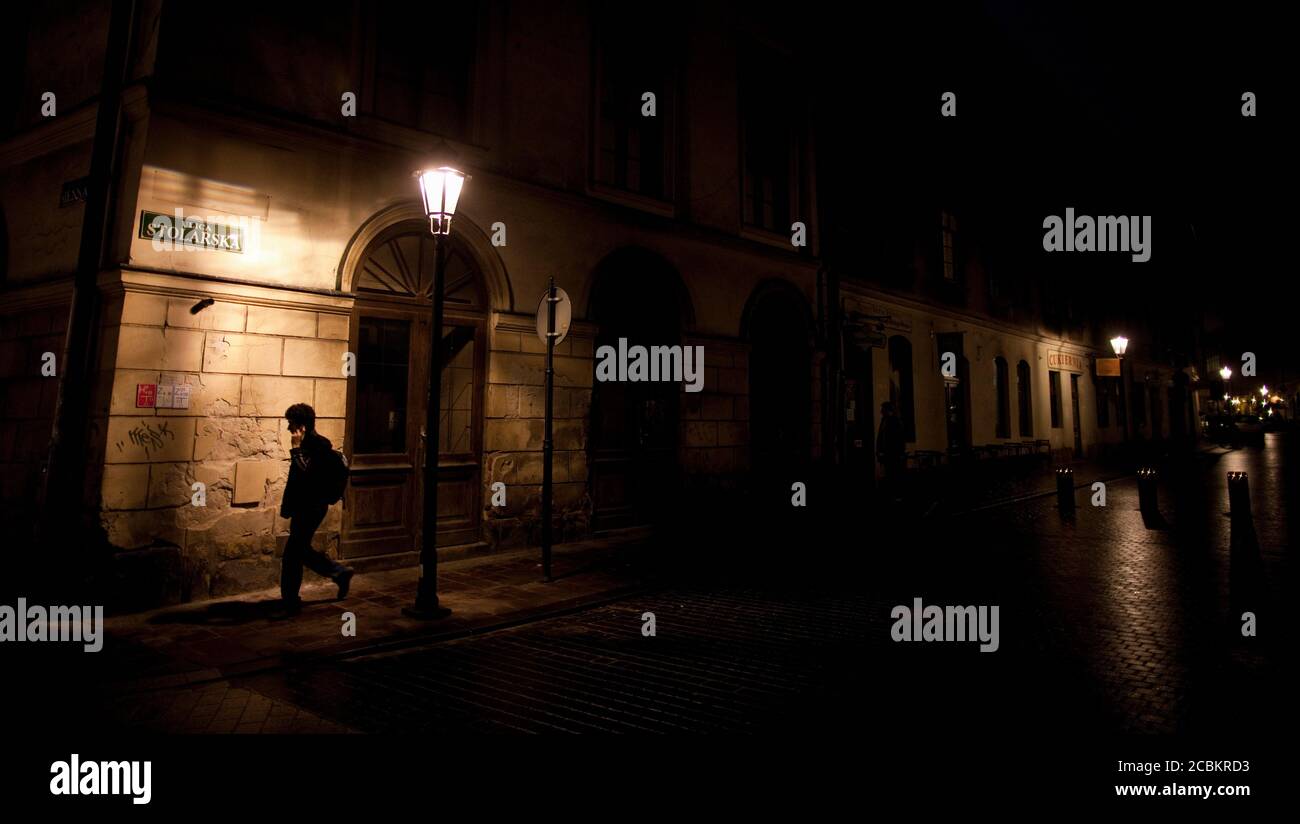 Woman walking on city street at night Stock Photo - Alamy