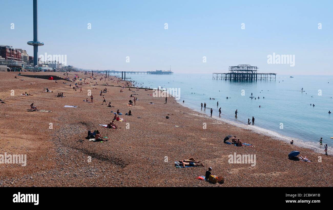 Brighton and Hove, E Sussex, UK - August 2020: Three landmarks seen from the beach. The i360 donut, West Pier and Palace Pier. Stock Photo