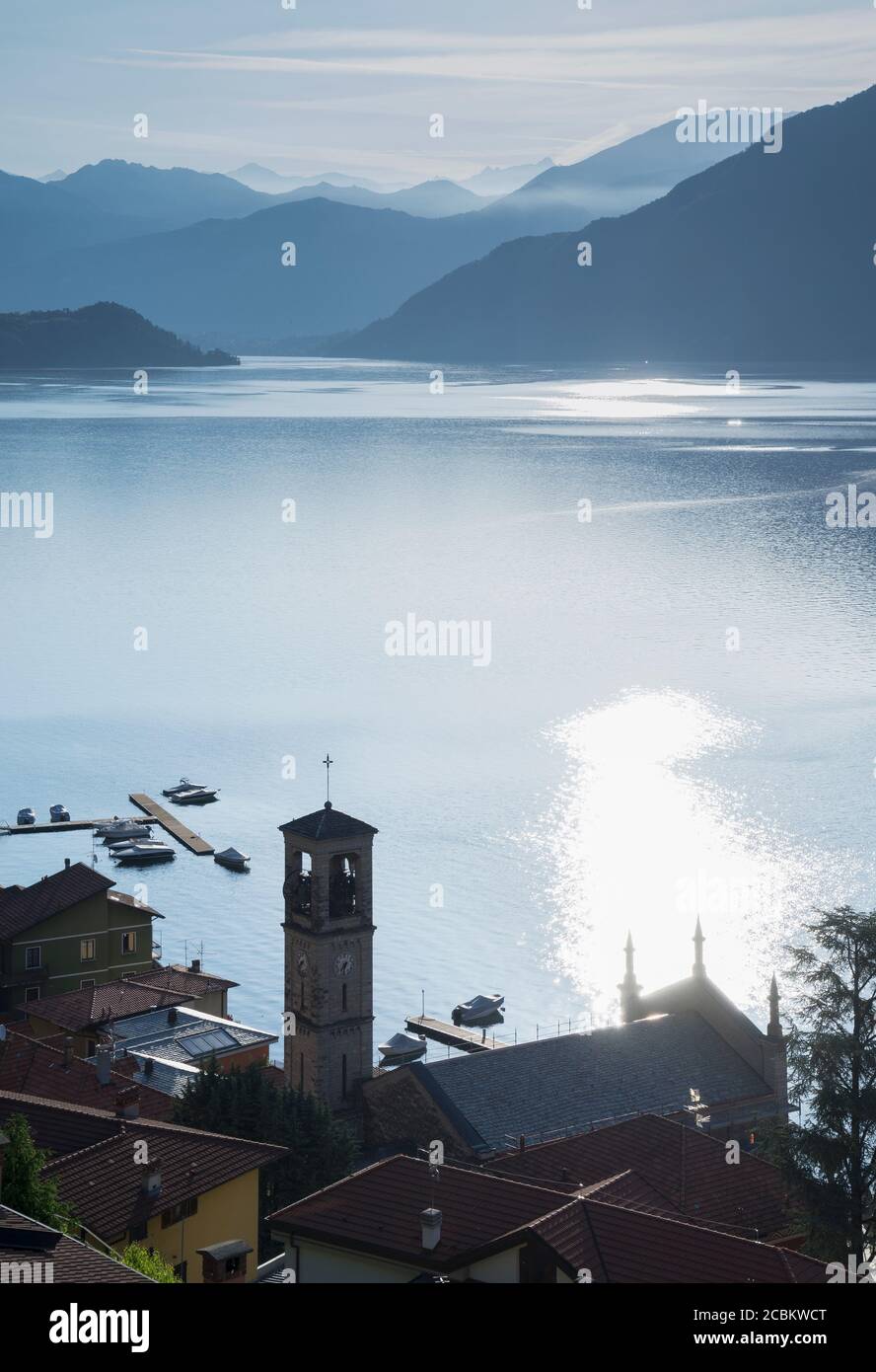 Waterfront village and distant mountains at sunrise,  Lake Como, Italy Stock Photo