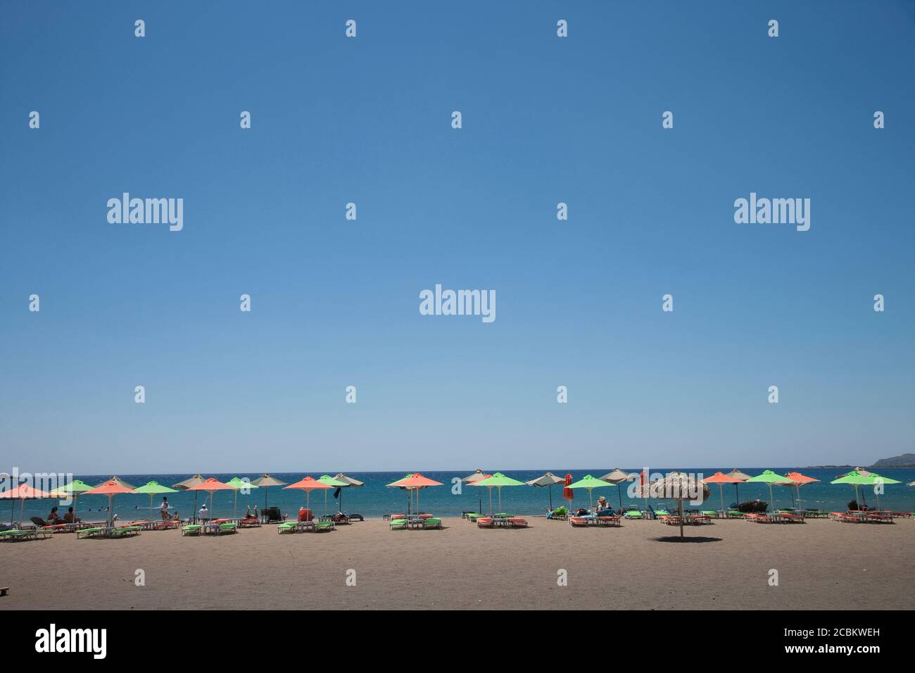 Sun umbrellas on beach at Giorgioupolis, Crete, Greece Stock Photo