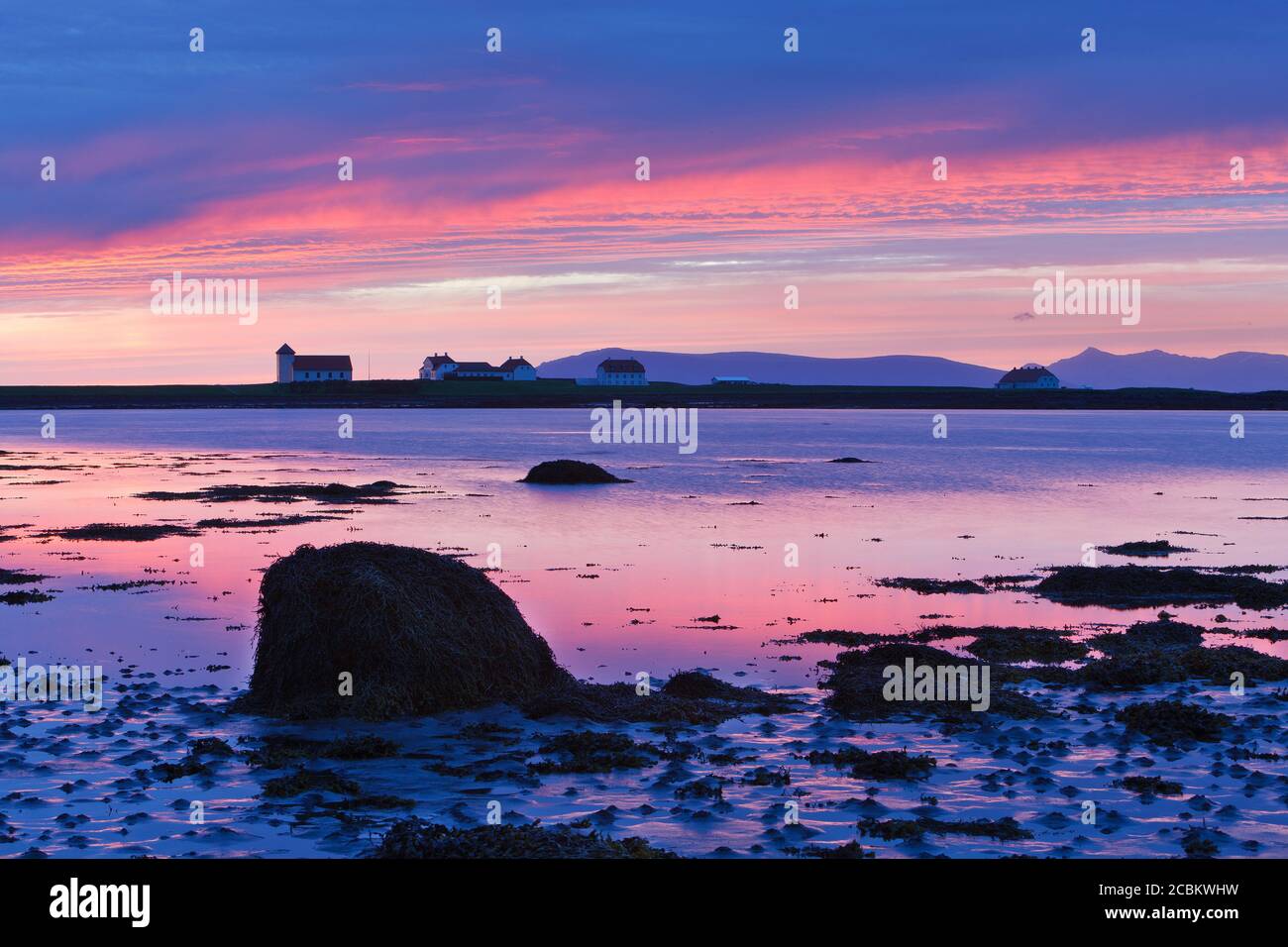 Rocky landscape and presidents residence building in remote setting at sunset, Bessastadir, Alftanes, Iceland Stock Photo