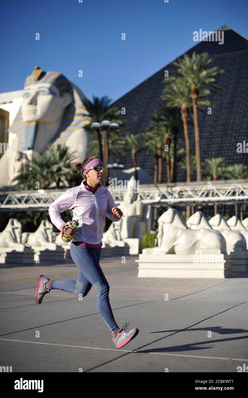 Mid adult female runner running in front of pyramid hotel on las Vegas Strip, Las Vegas, Nevada, USA Stock Photo