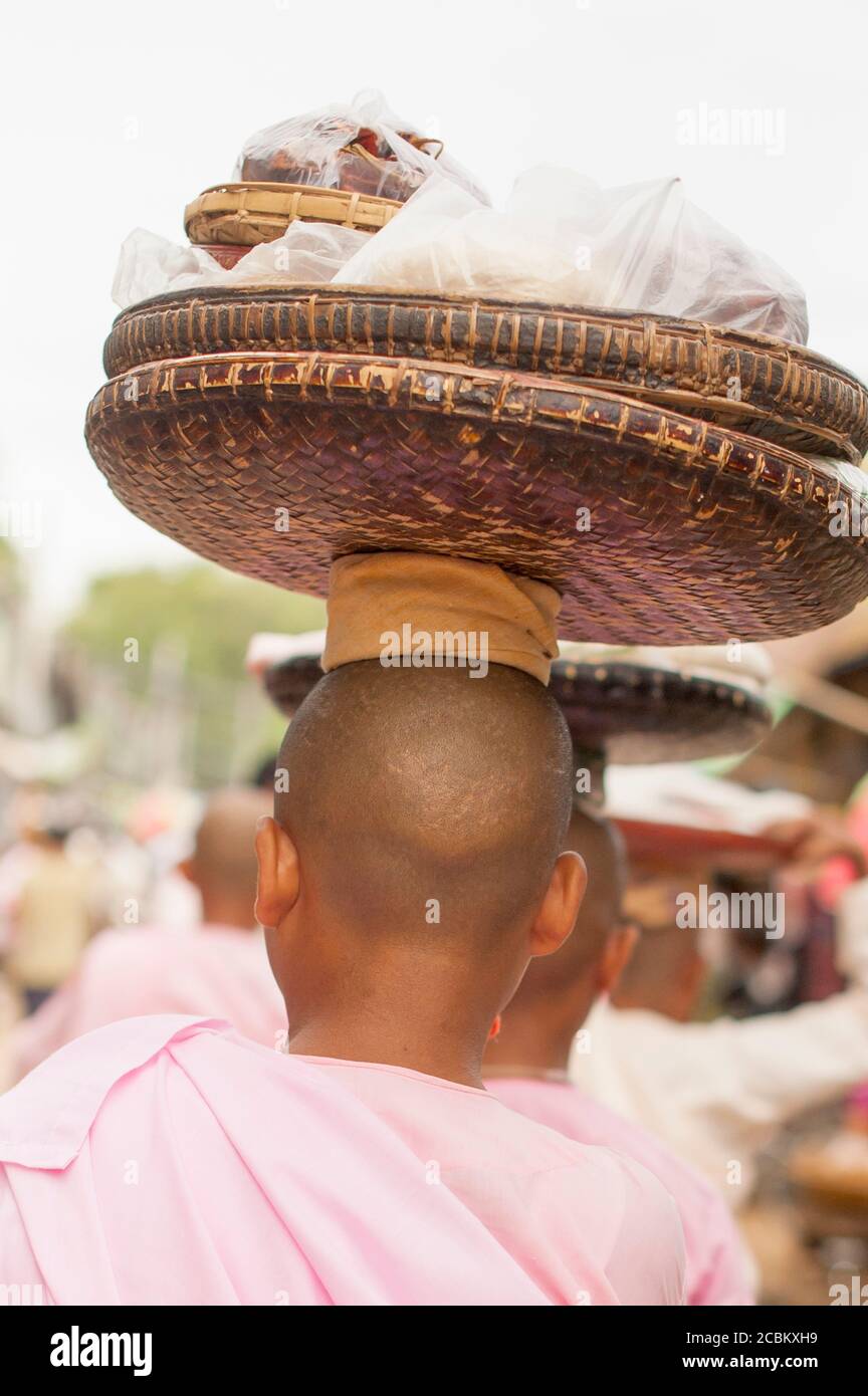 Young Buddhist Monks carrying baskets on head, Bagan, Myanmar Stock Photo
