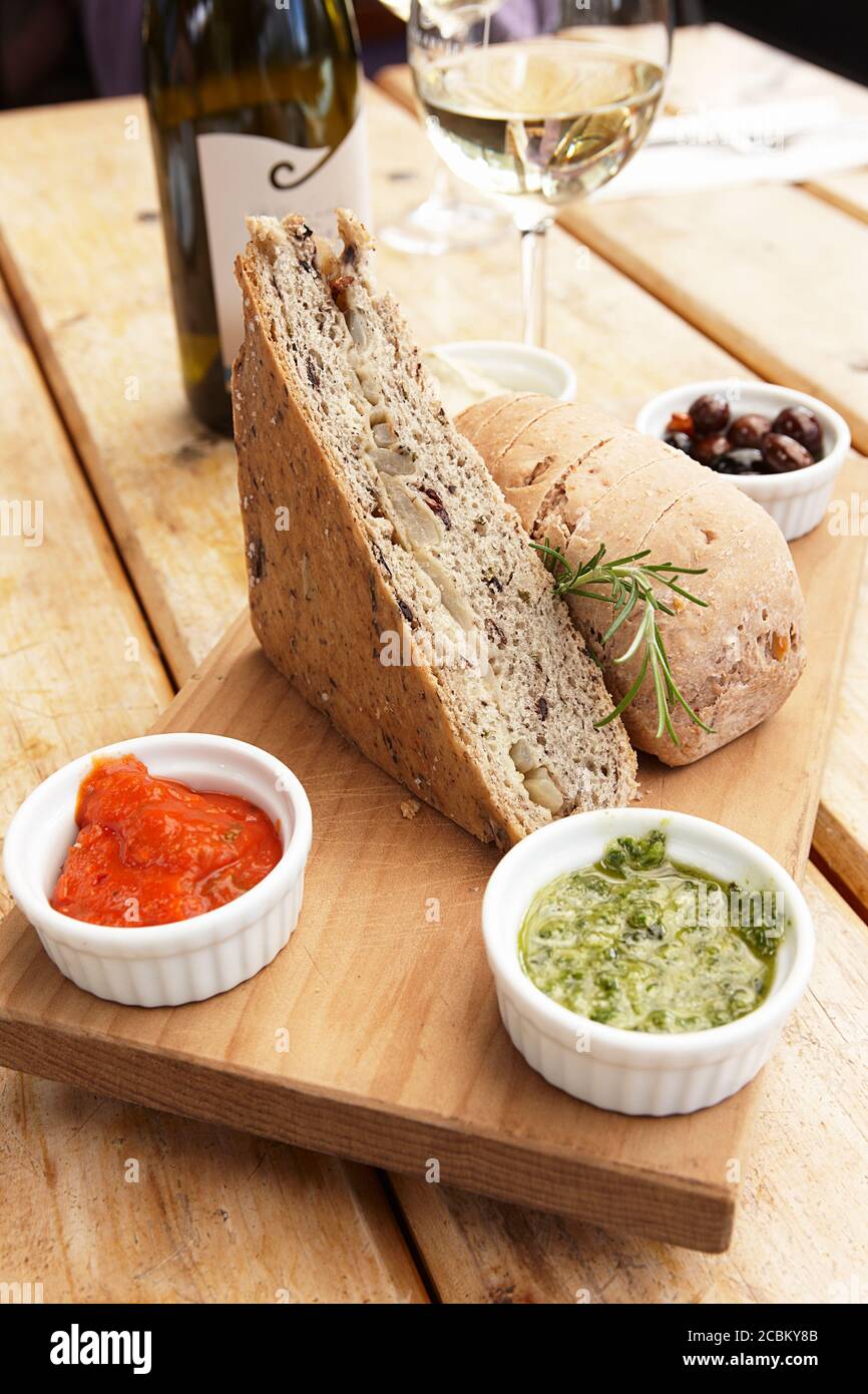 Still life with snack of bread, dipping sauces and white wine Stock