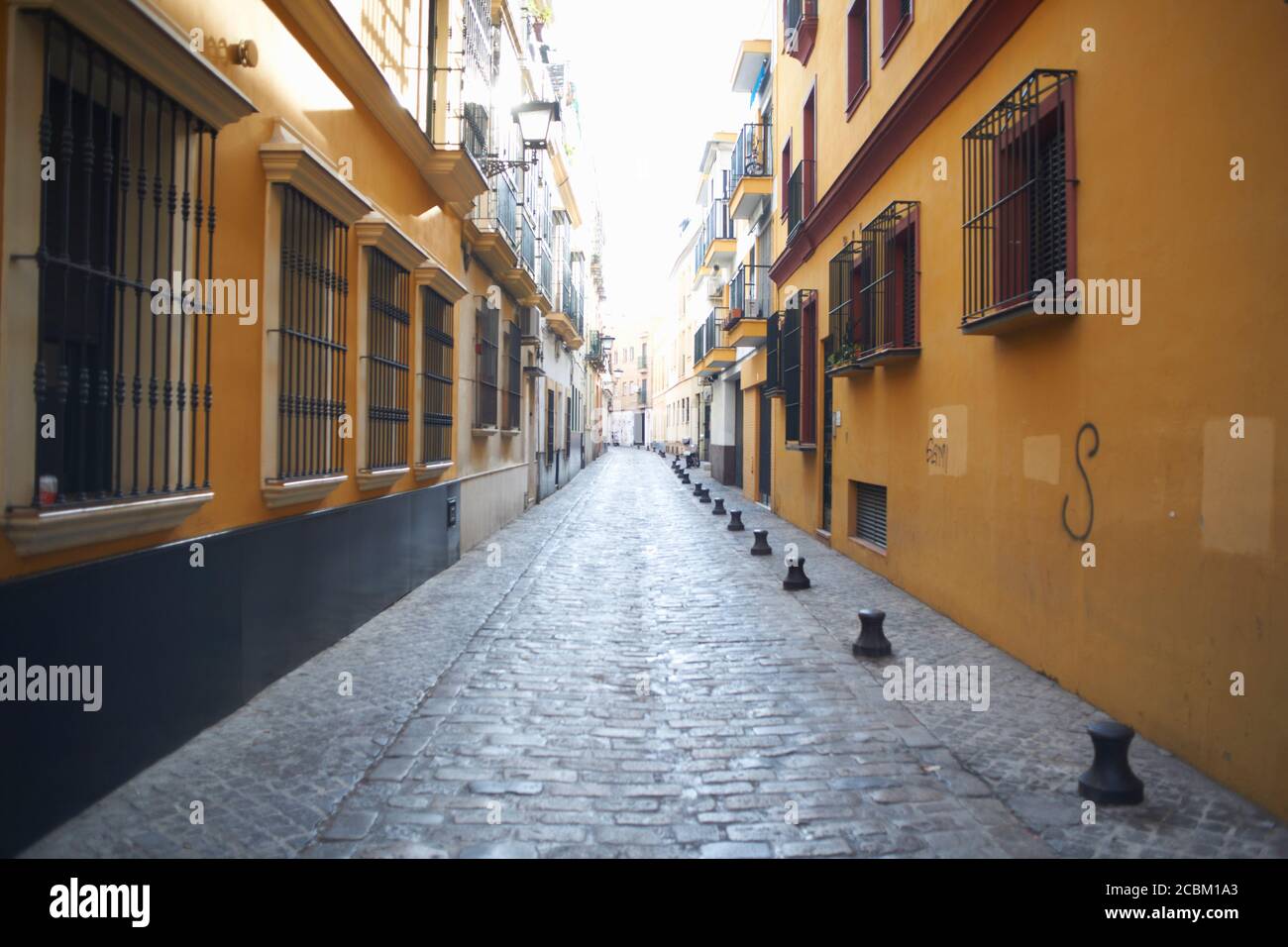 Traditional painted house exteriors on cobbled street, Seville, Andalusia, Spain Stock Photo