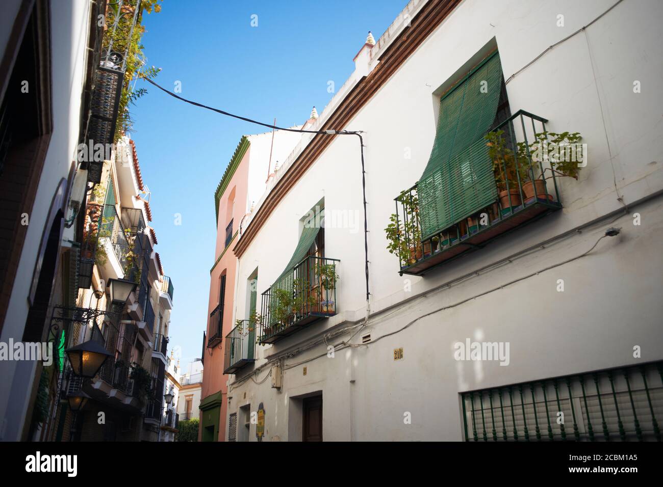 Traditional house exteriors on narrow street, Seville, Andalusia, Spain Stock Photo