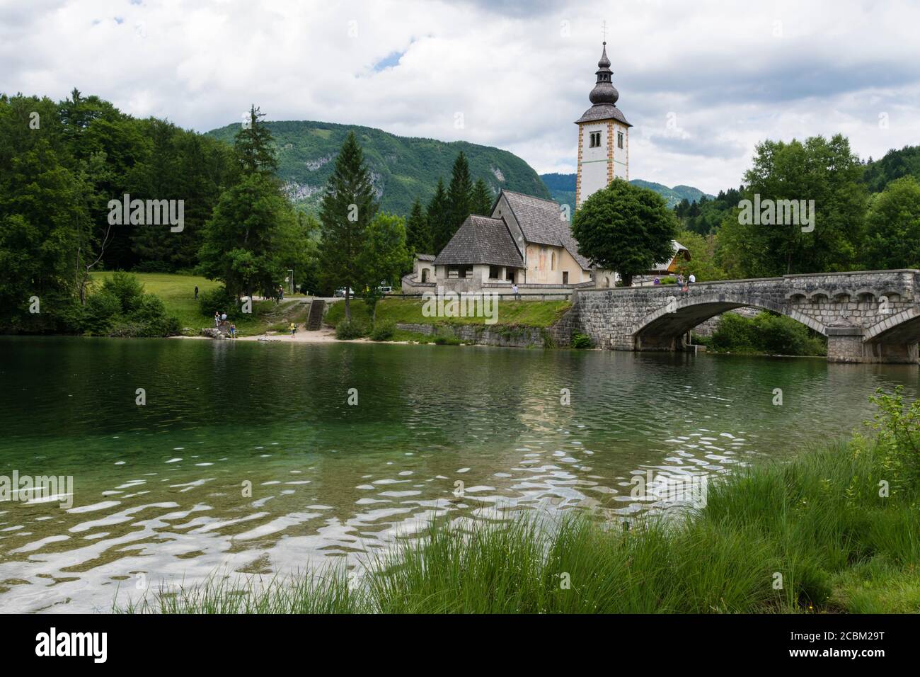 Church of St John the Baptist and the stone bridge over lake Bohinj ...