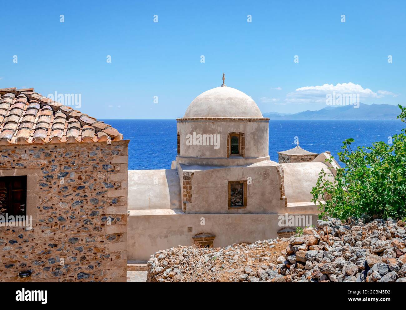 View to the Aegean Sea from the medieval town of Monemvasia, with a white byzantine church in the forground. Peloponnese, Greece. Stock Photo