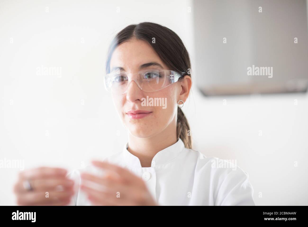 scientist female with lab glasses, tablet and sample in a lab Stock