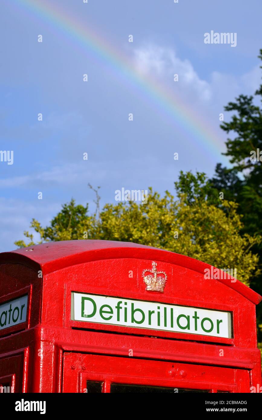 A telephone box repurposed as the base for a defibrillator in a village in Devon, England Stock Photo