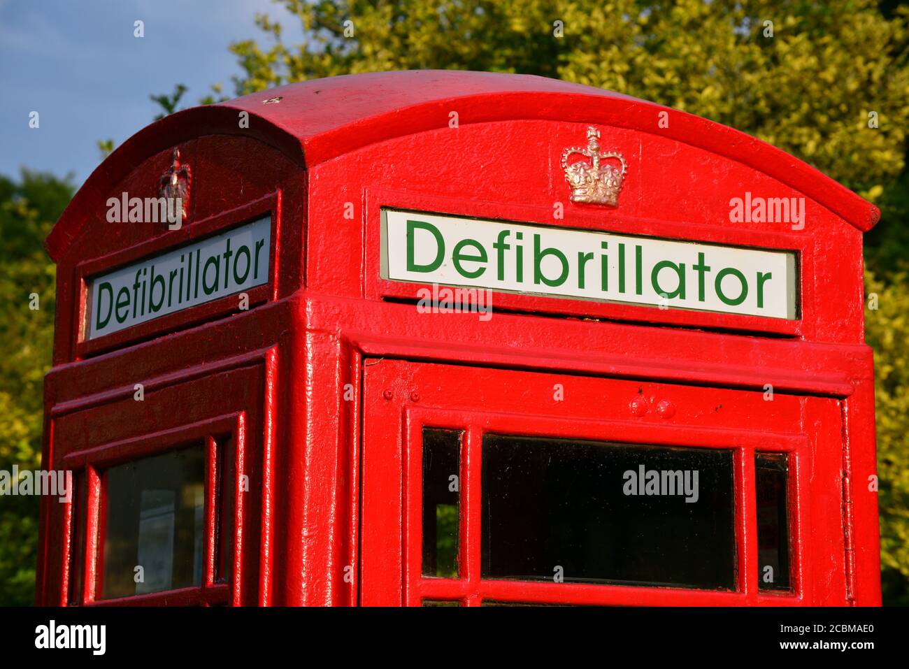 A telephone box repurposed as the base for a defibrillator in a village in Devon, England Stock Photo