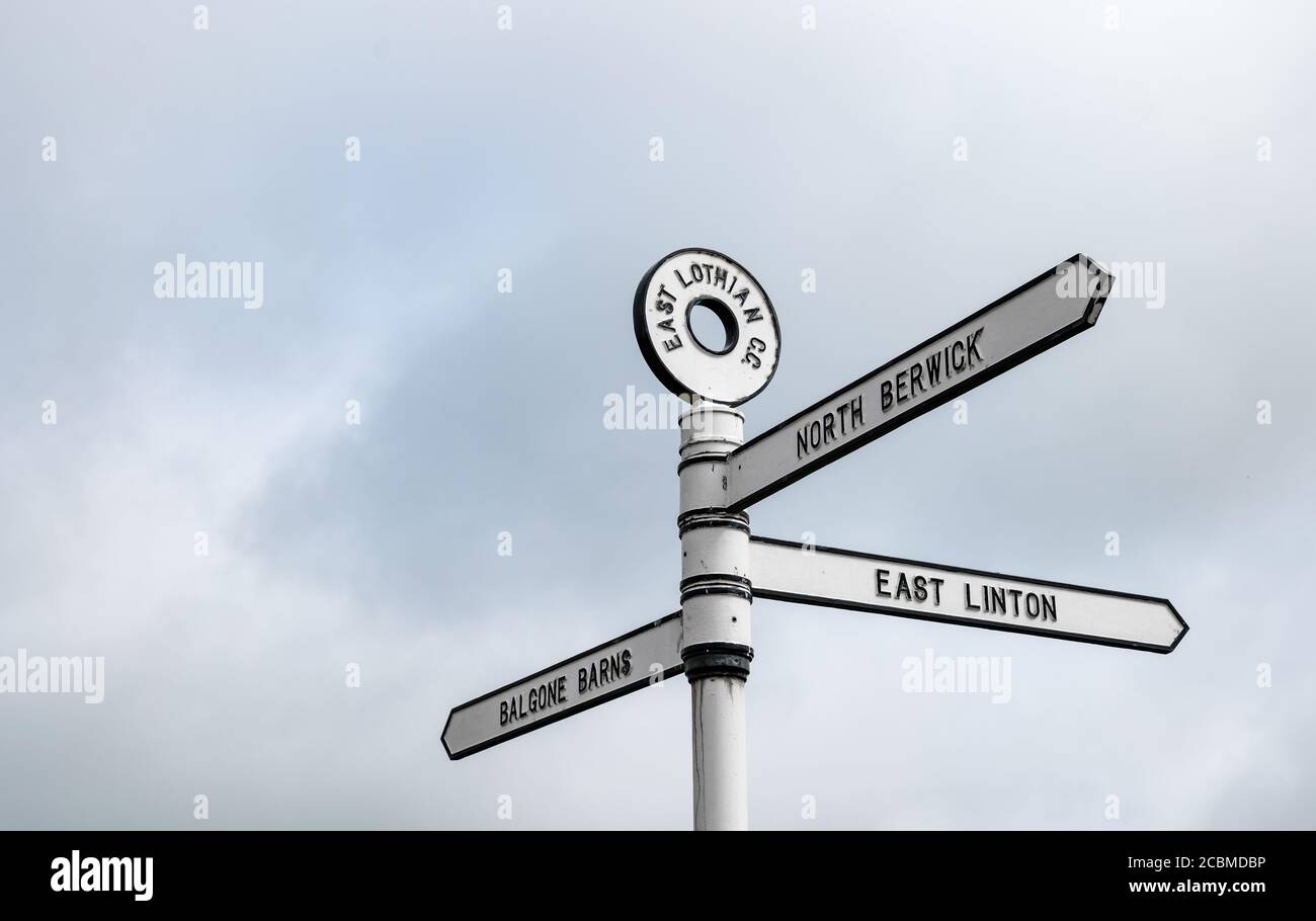 Old fashioned signpost with directions to North Berwick, East Linton & Balgone Barns, East Lothian, Scotland, UK Stock Photo