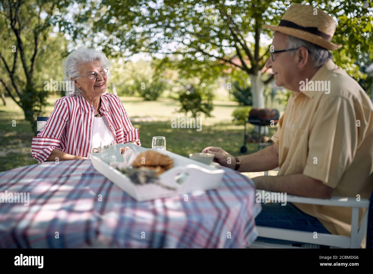 Smiling Senior Woman and Men enjoying together outdoor and drink coffee. Stock Photo