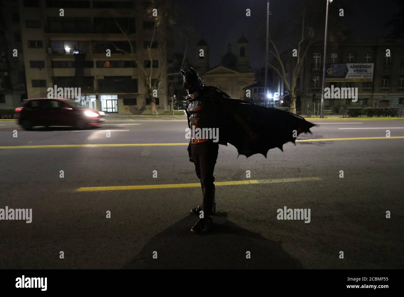 A Chilean trader and so-called 'Batman solidario' (Solidarity Batman) walks  after delivering charity food rations in the street, during the global  outbreak of the coronavirus disease (COVID-19) in Santiago, Chile August 12,