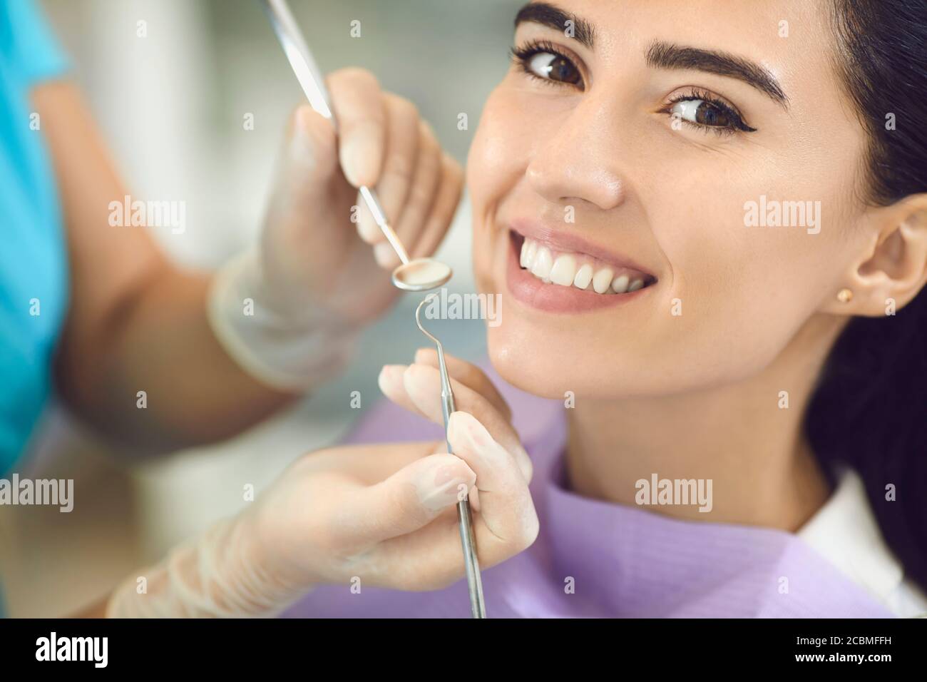 Dentist with gloves at the dental clinic examines the teeth in the