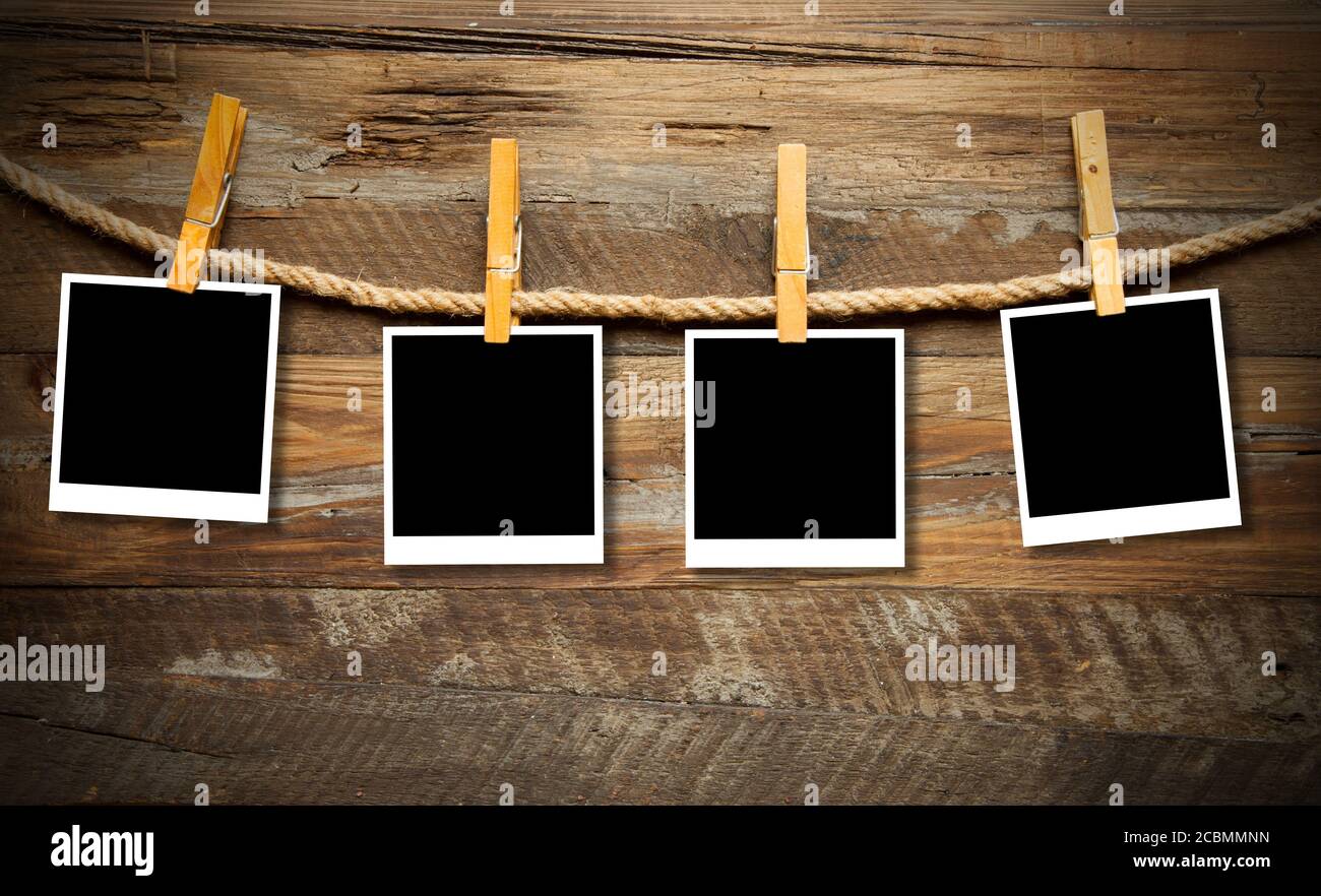 Polaroid photo frames hanging from a rope with pins Stock Photo - Alamy