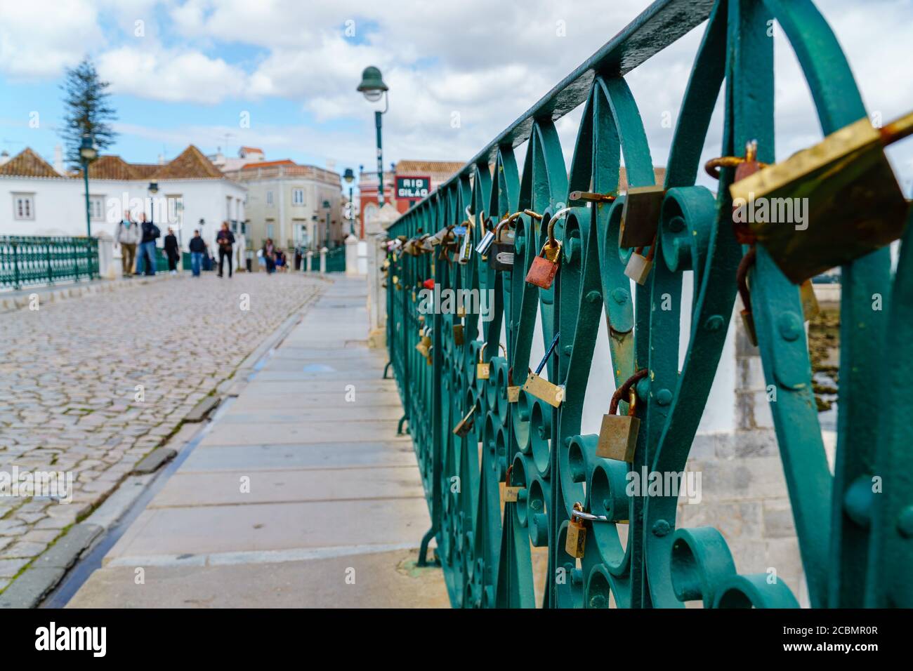 Tavira, Portugal - March 24, 2018: Love locks hanging on bridge railing. Loving couples attach padlocks as symbol of eternal love. Stock Photo