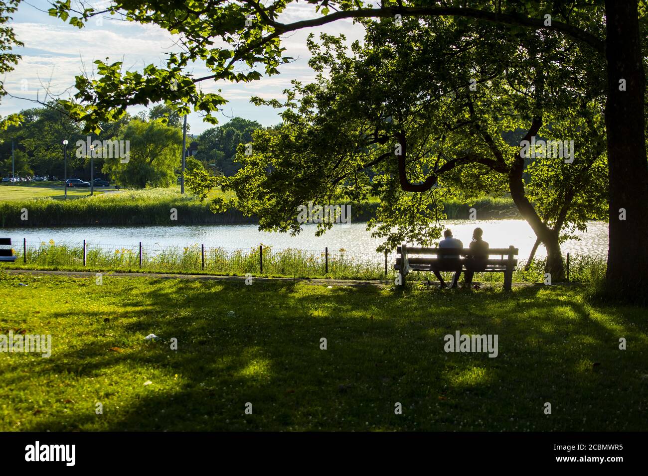 a couple silhouette sitting romantically on a park bench Stock Photo ...