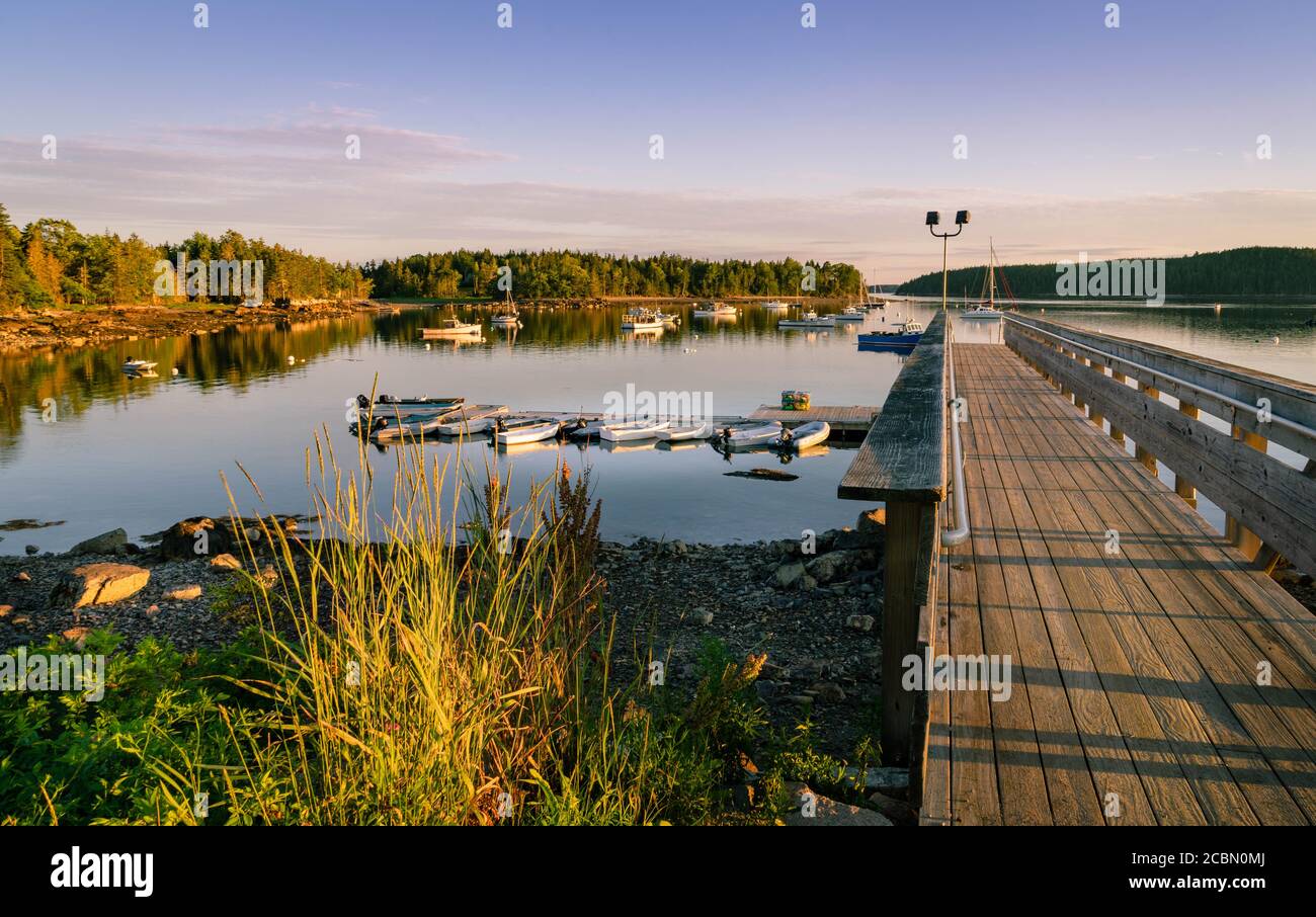 Beautiful sunset view of boats and a dock in a cove in Pretty Marsh in Maine. Stock Photo
