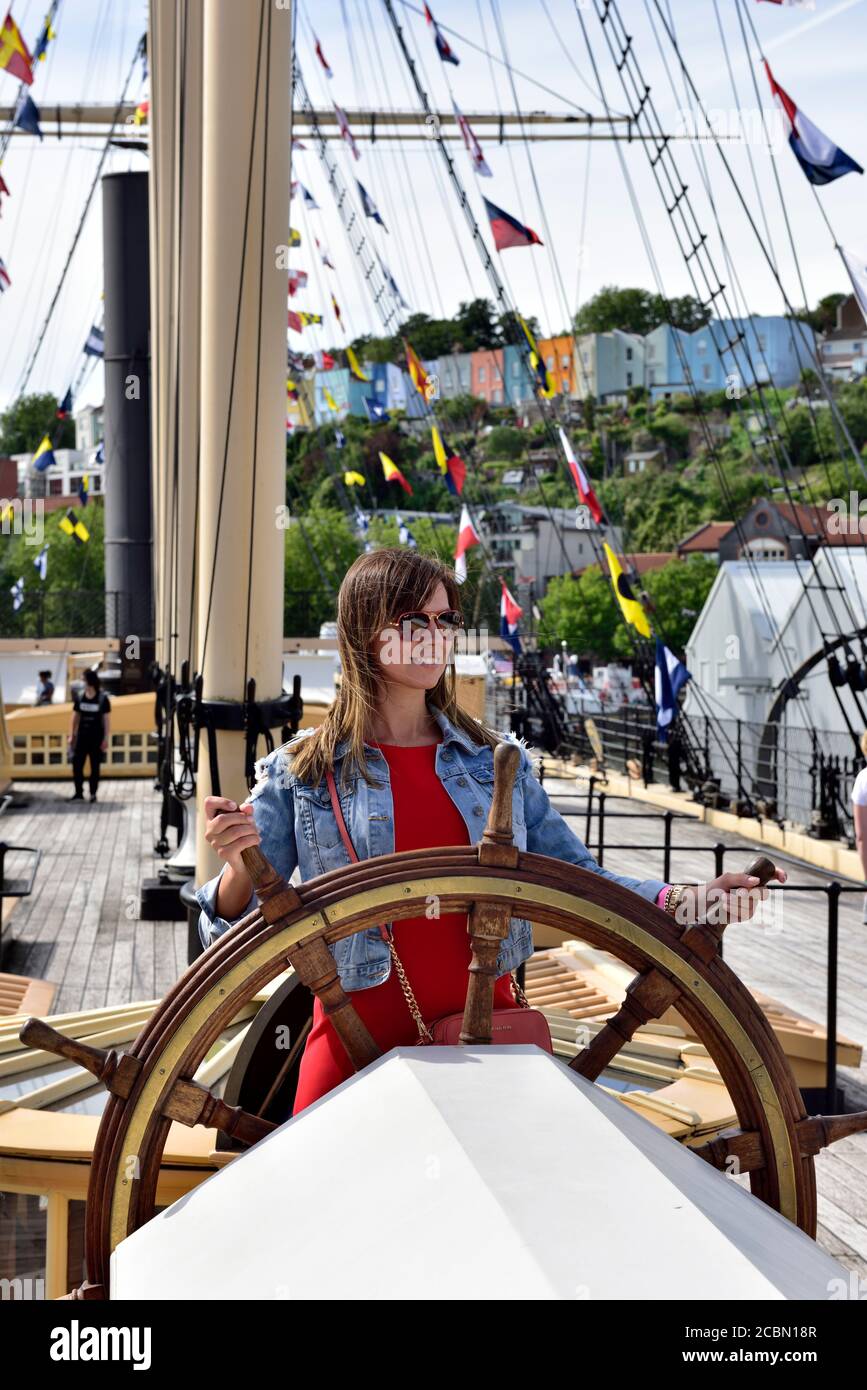 Tourist hold the stern steering wheel of Isambard Kingdom Brunel's SS Great Britain in Great Western Dockyard in Bristol Stock Photo