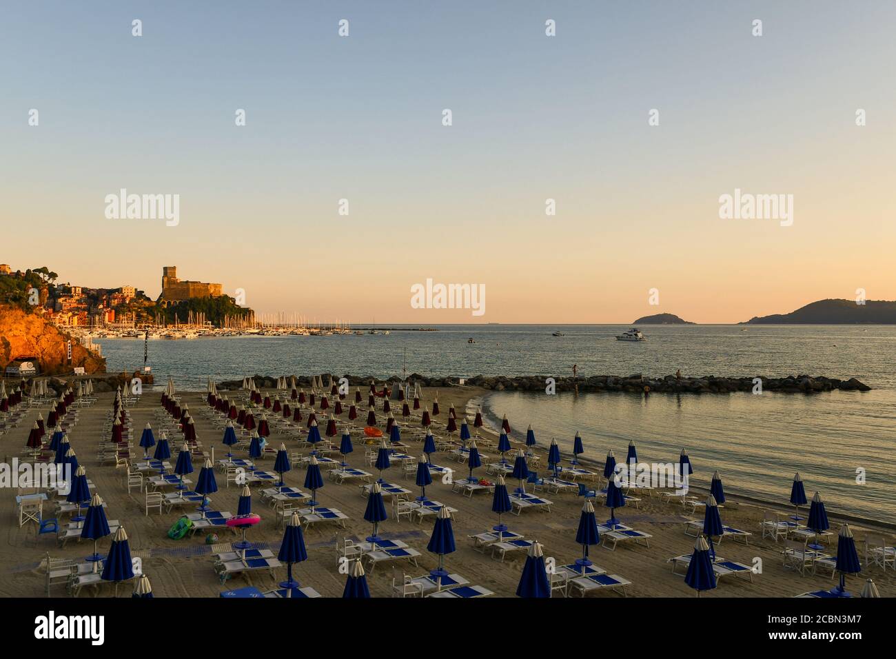 Elevated view of the Gulf of Poets with a beach, the fishing village and the Tino Island on the horizon at sunset, Lerici, La Spezia, Liguria, Italy Stock Photo