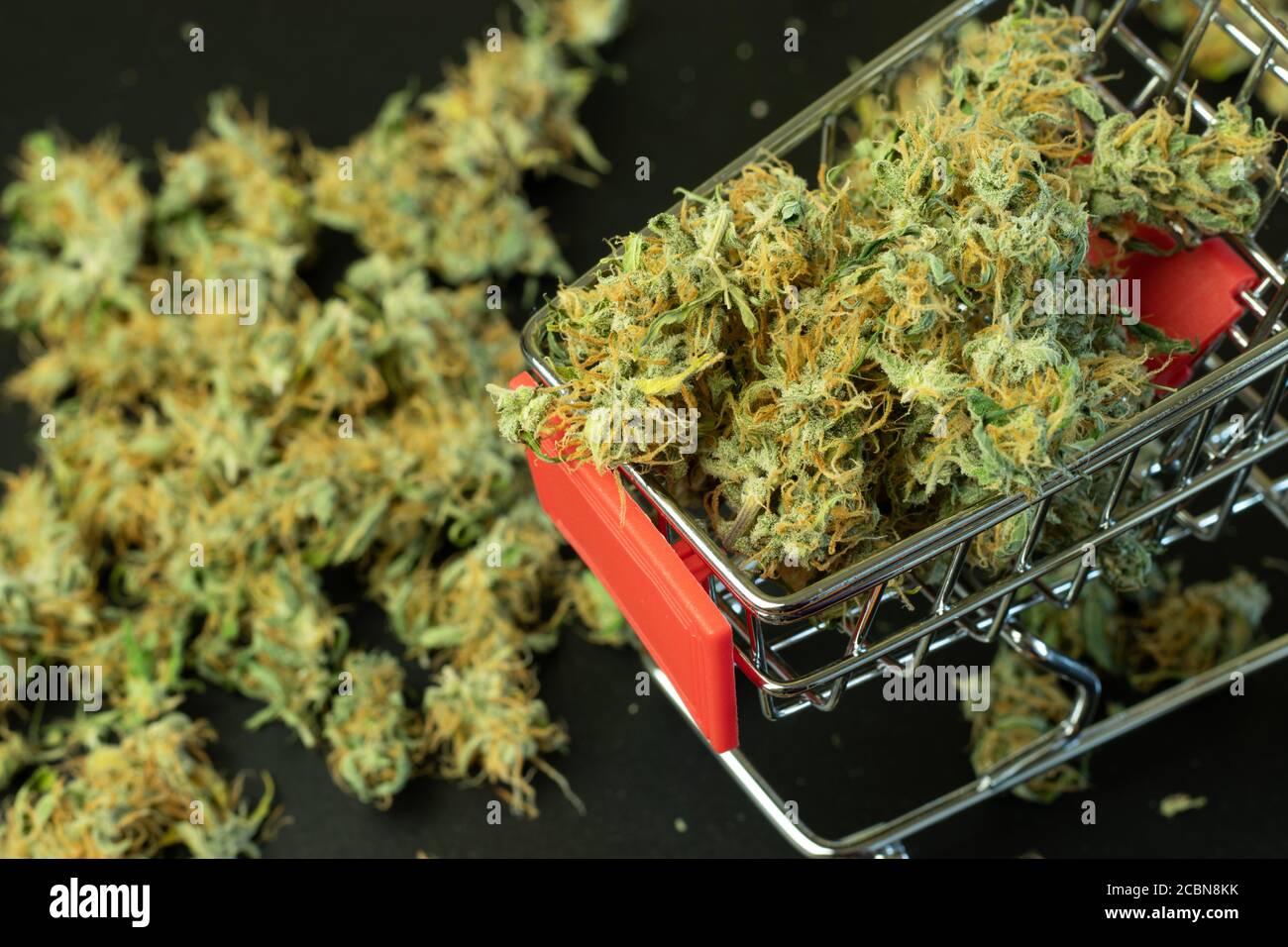 Shopping cart with marijuana buds load. Cannabis business concept Stock