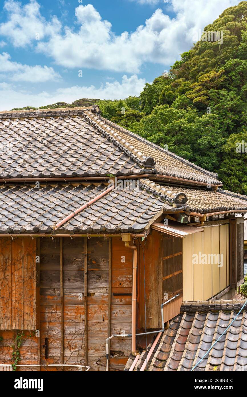 Close-up on a hip roof named yosemunezukuri ornate with decorative Onigawara tile at the end of the ridge and wooden facade named sasarako-shitami of Stock Photo
