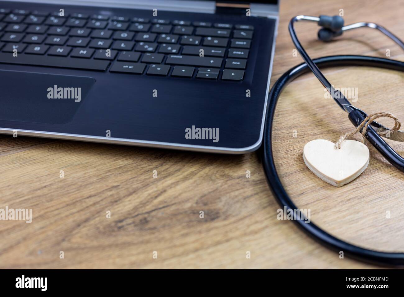 hospital workstation with stethoscope and wooden heart Stock Photo