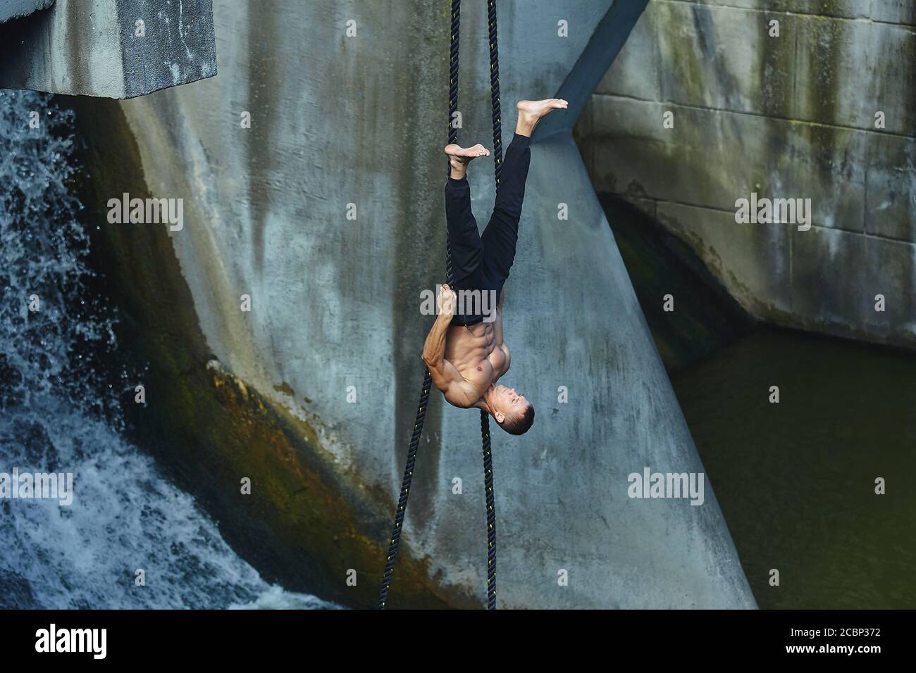 an athletic person performs dangerous exercises on a gymnastic rope. in