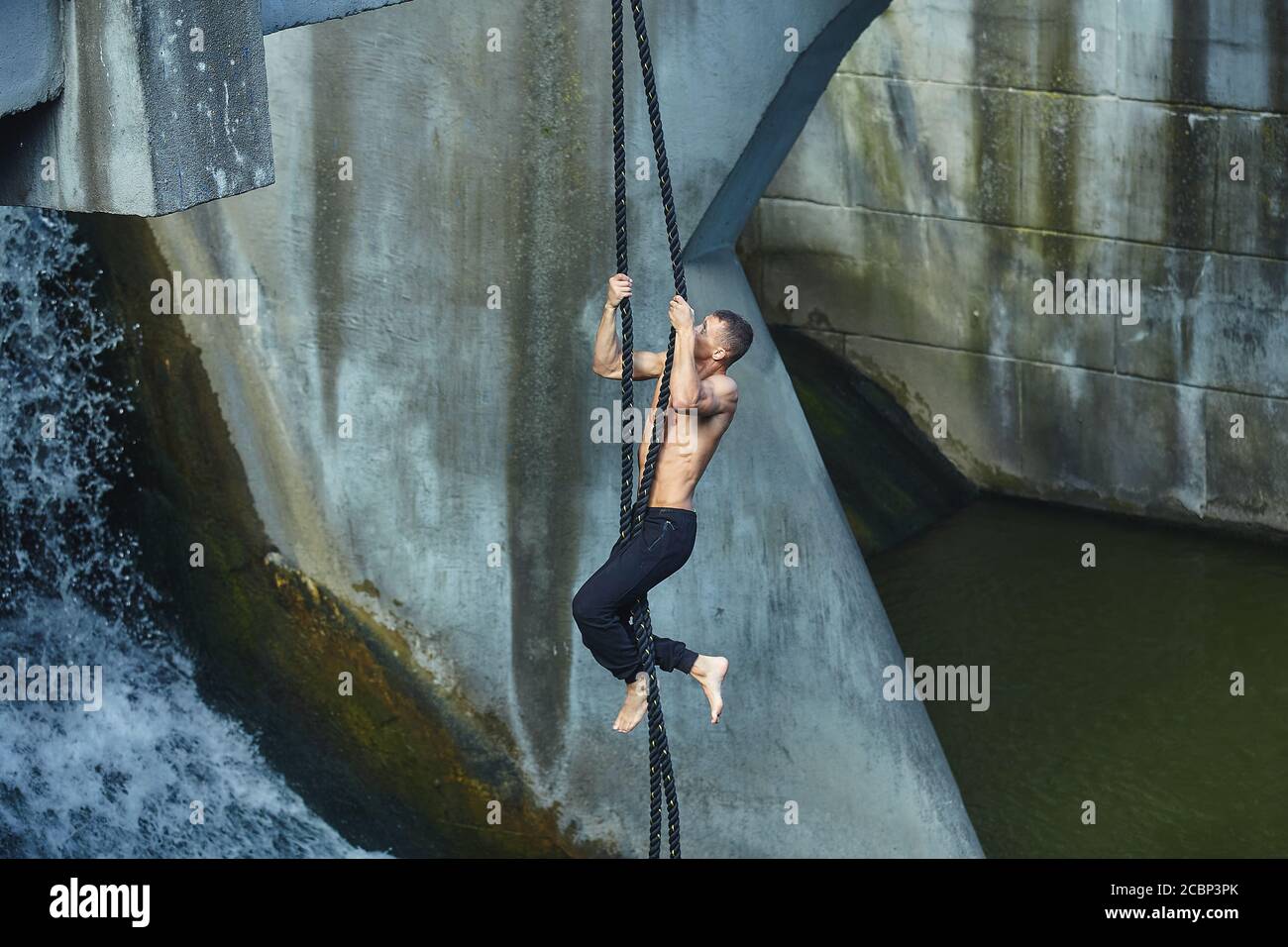an athletic person performs dangerous exercises on a gymnastic rope. in