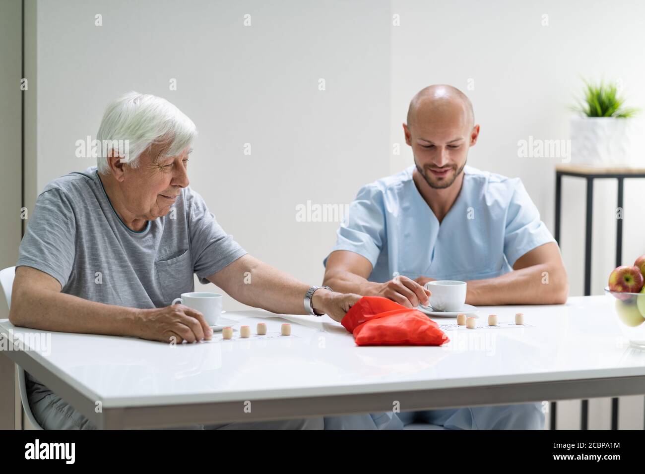 Elderly Senior Playing Lotto With Caregiver At Home Stock Photo