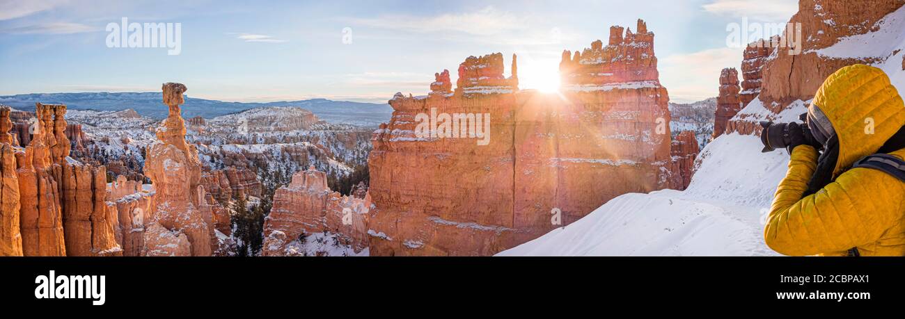 Tourist taking pictures, rock formation Thors Hammer, morning light, sunrise, bizarre snowy rock landscape with hoodoos in winter, Navajo Loop Trail Stock Photo